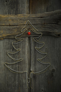 Christmas tree shaped of chains on wood