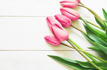 Bouquet of tulips on a white wooden background with a space for text
