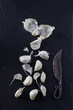 Cloves of garlic with old knife