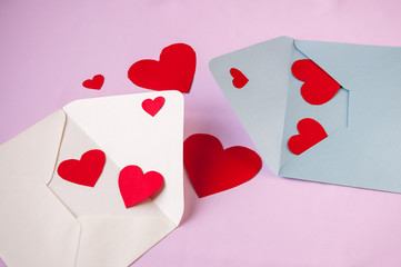 Valentine's day card: two envelopes with red hearts on a pink background