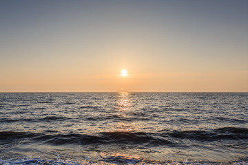 Sunset at the sea. Small waves.