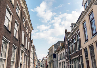 Fototapeta na wymiar Street with old houses under blue cloudy sky. Deventer, Overijssel, Netherlands.