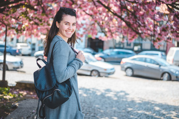 Fototapeta premium young cheerful woman under bloomin sakura