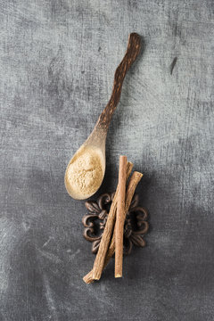 Licorice roots and spoon of licorice powder