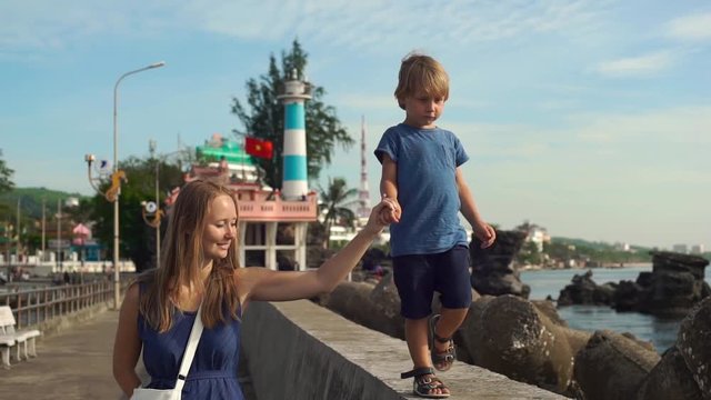 Young woman and her son walking around Dinh Cau lighthouse symbol of the island Phu Quoc, Vietnam