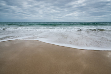 Fototapeta na wymiar plage deserte avec de l'écume