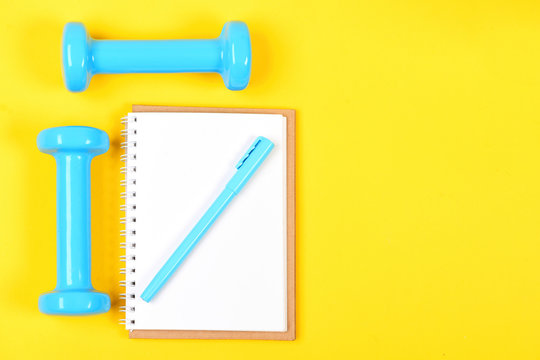 Weight loss and active lifestyle concept. Notepad and fitness tools