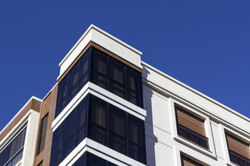 Corner view of closed balcony from modern facade building in the morning time