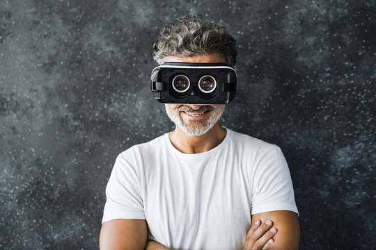 Mature man looking through VR glasses backwards