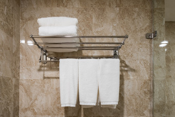 Fototapeta na wymiar White clean towel hanging with stacked on rail in bathroom