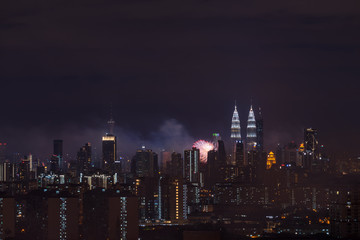 Fototapeta na wymiar KUALA LUMPUR, MALAYSIA - 1ST JANUARY 2018; Fireworks explode near Malaysia's landmark Petronas Twin Towers during New Year celebrations in Kuala Lumpur.