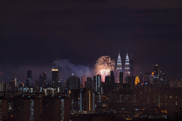 Fototapeta premium KUALA LUMPUR, MALAYSIA - 1ST JANUARY 2018; Fireworks explode near Malaysia's landmark Petronas Twin Towers during New Year celebrations in Kuala Lumpur.