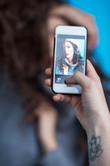 cropped shot of person using smartphone and photographing sensual young woman