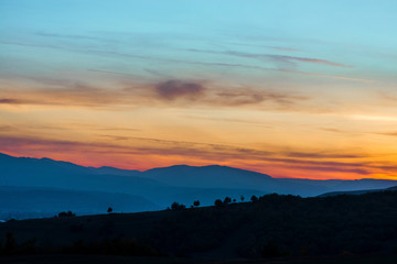 Romantic, bright and colorful sunset over a mountain range in Transilvania. Beautiful, colorful autumn background