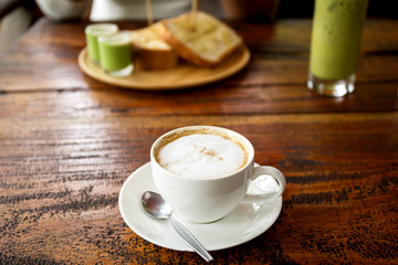 Cup of coffee with bread on wooden table