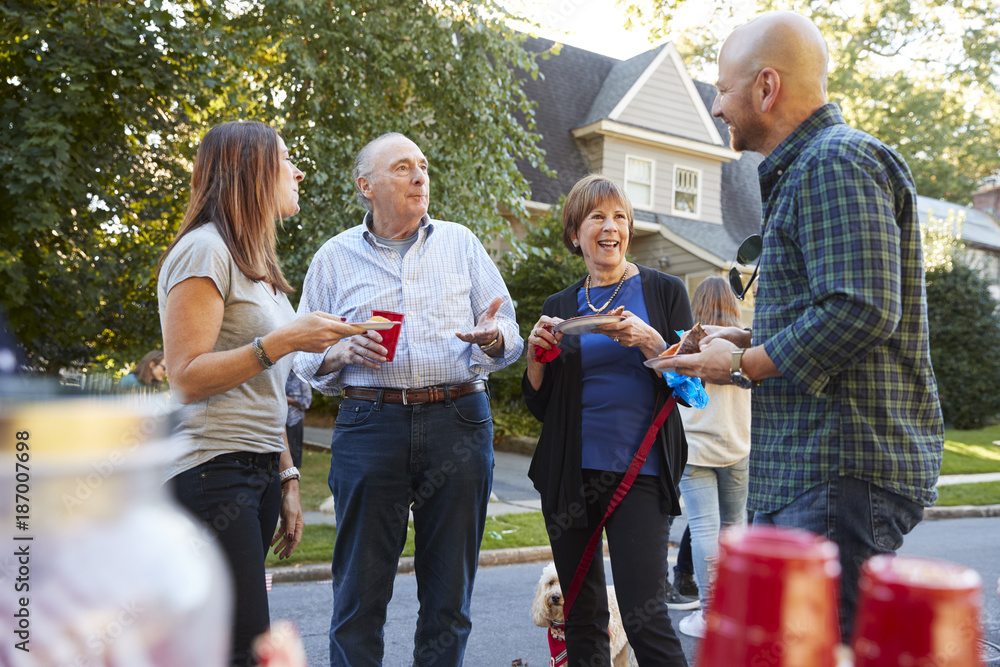 Wall mural middle aged and senior neighbours talking at a block party