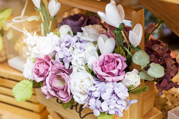 Artificial flower in the pot over wood table