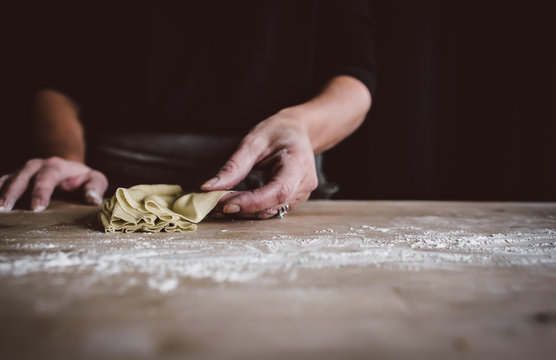 Hands of woman making pasta in kitchen