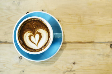 Hot coffee drawing heart in blue cup