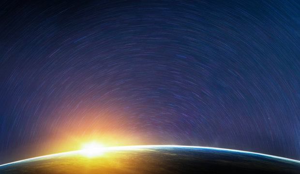 Landscape image of Earth, sunrise and star trail view from space. (Elements of this image furnished by NASA)