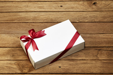 gift box with red bow on wood