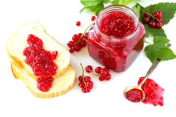 Homemade jam. Glass jar and jam on a bread with red currant on a white background. Preserved berry.