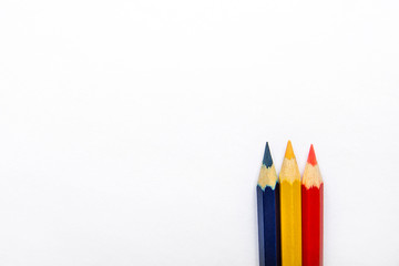 Row of Three Multicolored Pencils Red Yellow Blue in Bottom and Top on White Paper Background. Business Creativity Graphic Design Crafts Kids School Concept. Copy Space