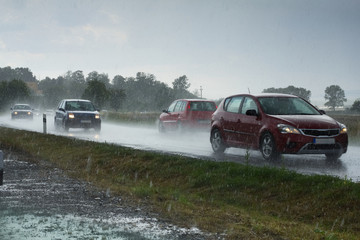 Fototapeta na wymiar traffic on a road during the heavy rain, driving cars in rainy day