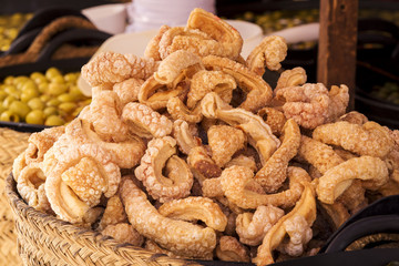 Rich fried and crunchy pork rinds sold in a market stall
