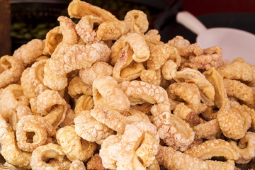 Rich fried and crunchy pork rinds sold in a market stall
