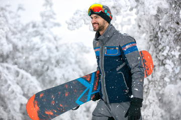 Snowboarder with snowboard going to ski terrain