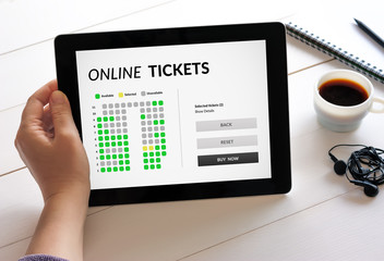 Hand holding digital tablet computer with online tickets concept on screen. All screen content is designed by me