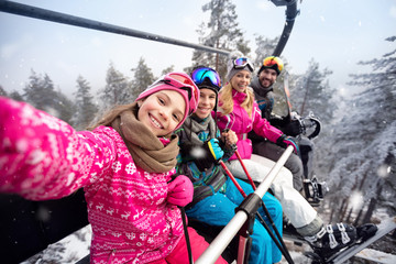 Glückliche Familie im Seilbahnaufstieg zum Skigebiet