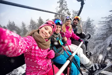 Abwaschbare Fototapete Wintersport Glückliche Familie im Seilbahnaufstieg zum Skigebiet