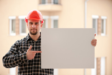 Construction worker holding blank white board - Powered by Adobe