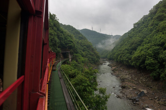 Beautiful scenery of the Katsura river seen from the red wagons of the Sagano Scenic Railway, Kyoto, Japan