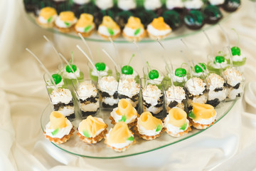 Delicious sweets on wedding candy buffet with desserts, cupcakes