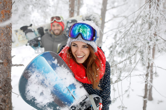 Woman with snowboard in forest