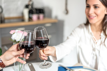 Happy young couple eating and drinking wine at home