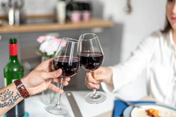 Happy young couple eating and drinking wine at home