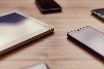 black phones and the white tablet on the table