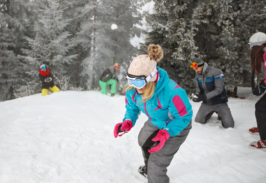 Group sportspeople on mountain making snowballs