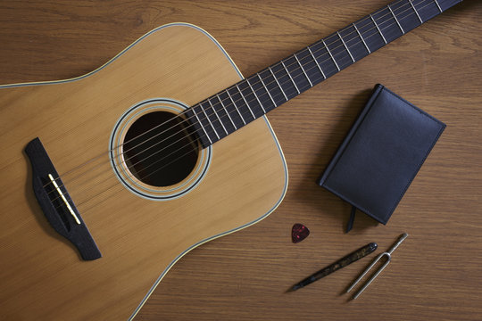 Acoustic guitar and tuning fork lying on floor