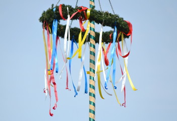 colorful german maypole in front of blue sky at spring