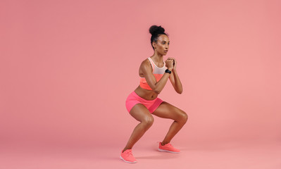 Fototapeta na wymiar Sporty woman practicing squat exercise