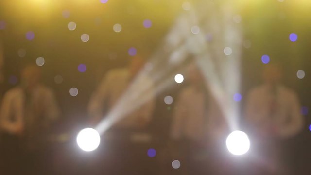Background of the dance is blurred people dancing in a nightclub. Blue and purple colors