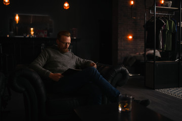 Customer reading a magazine in barbershop