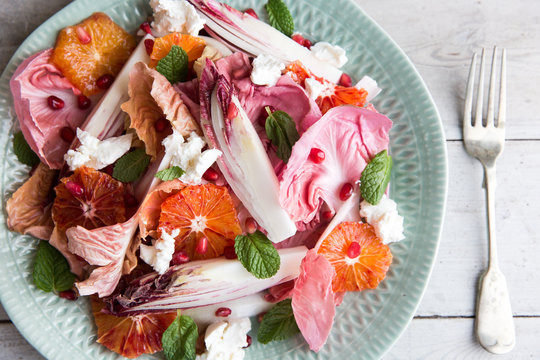 A salad of red chicory, pink endive and blood orange, with ricotta and pommegranate.