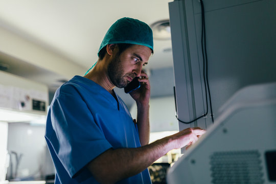 IVF Biologist on phone while manipulating an incubator