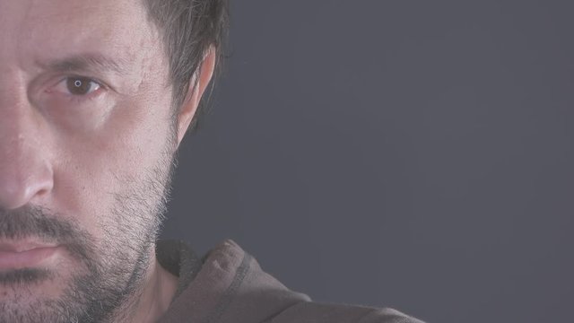 Half face portrait of pensive man, adult caucasian male looking at camera and thinking, ungraded flat style footage